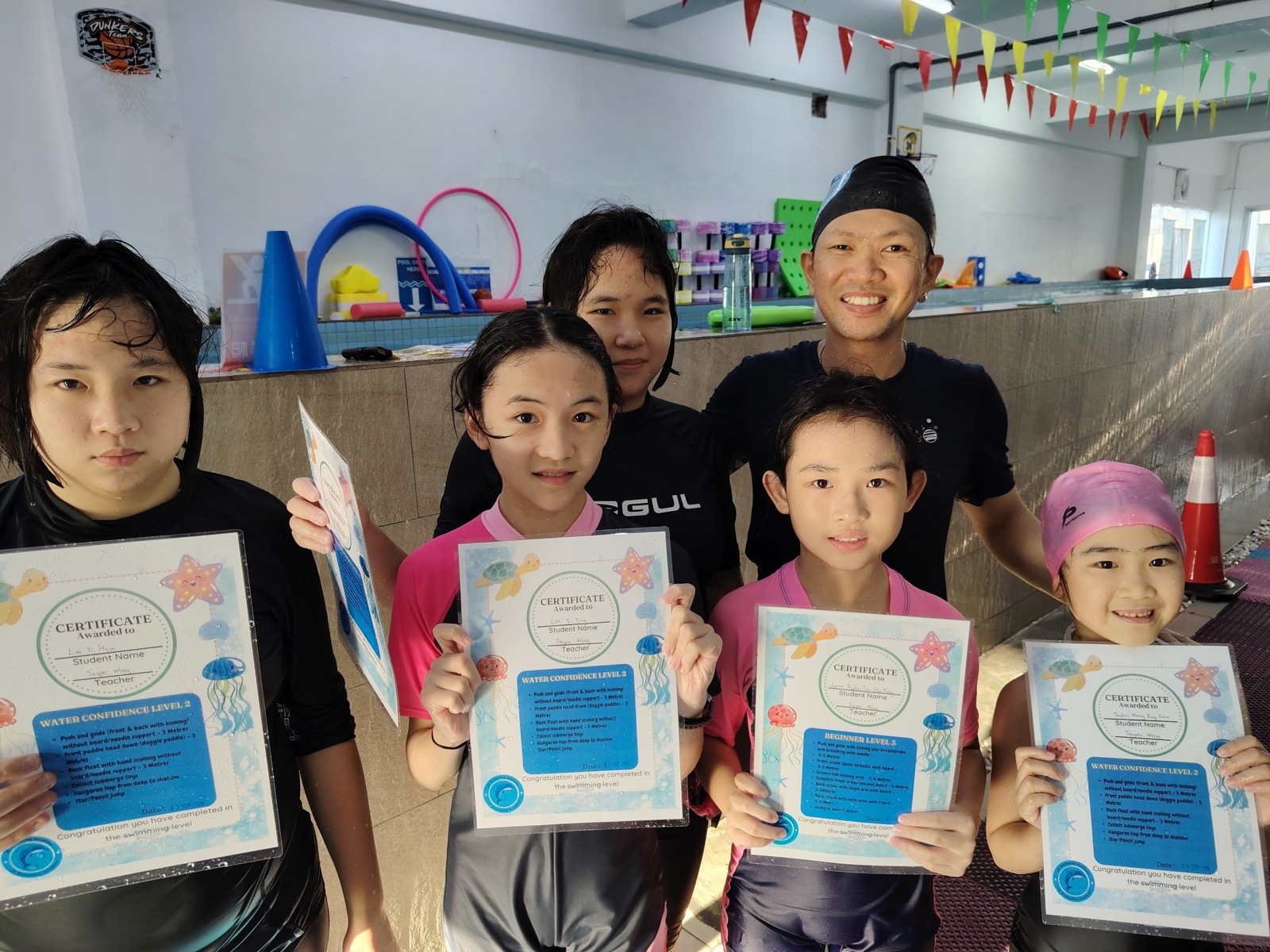 JC Swimming coaches and students proudly holding their Water Confidence certificates