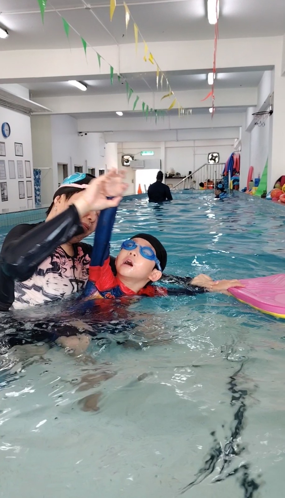 Young swimmers cheering with hands raised in the pool