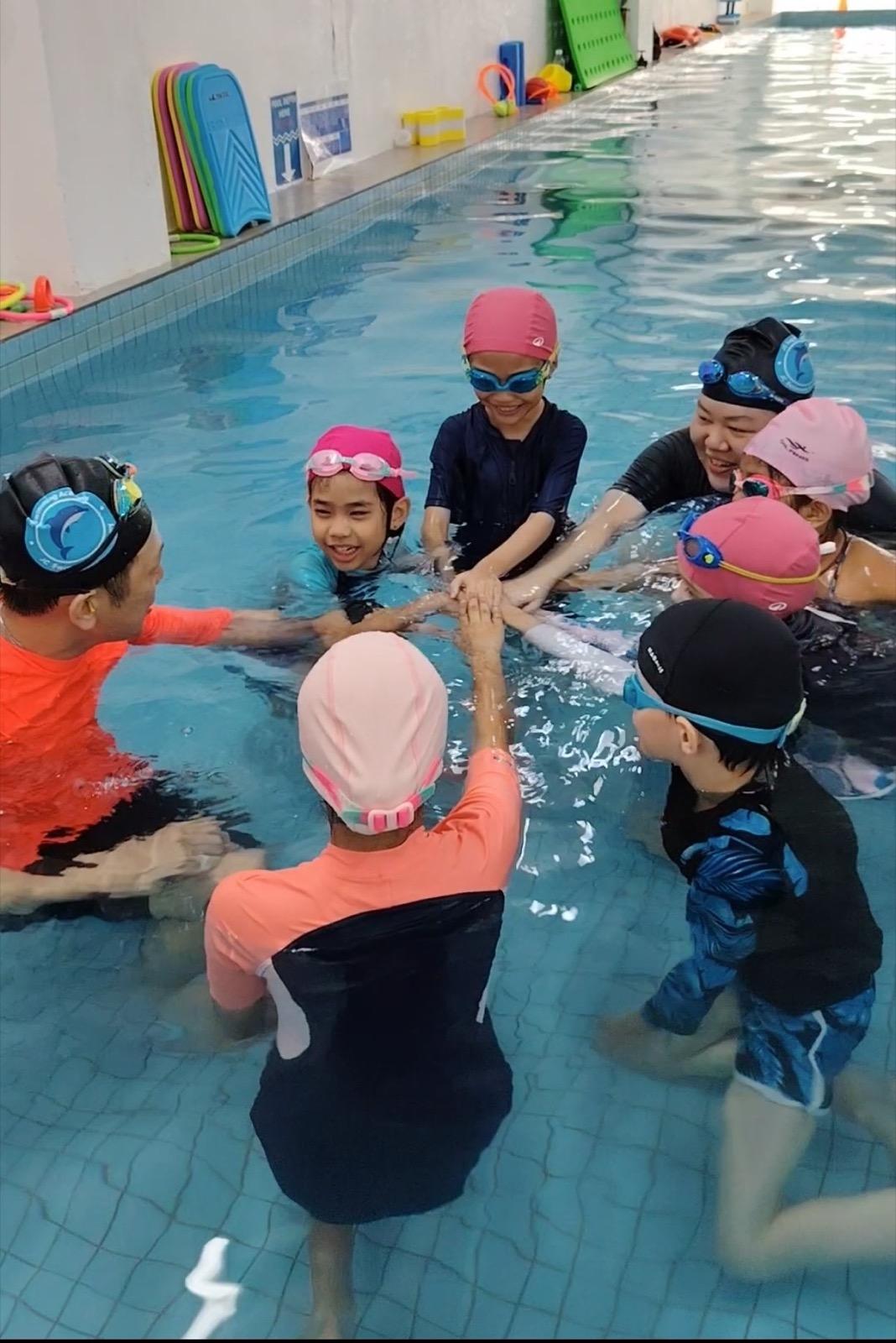 Swimmers practising their stroke technique at the poolside