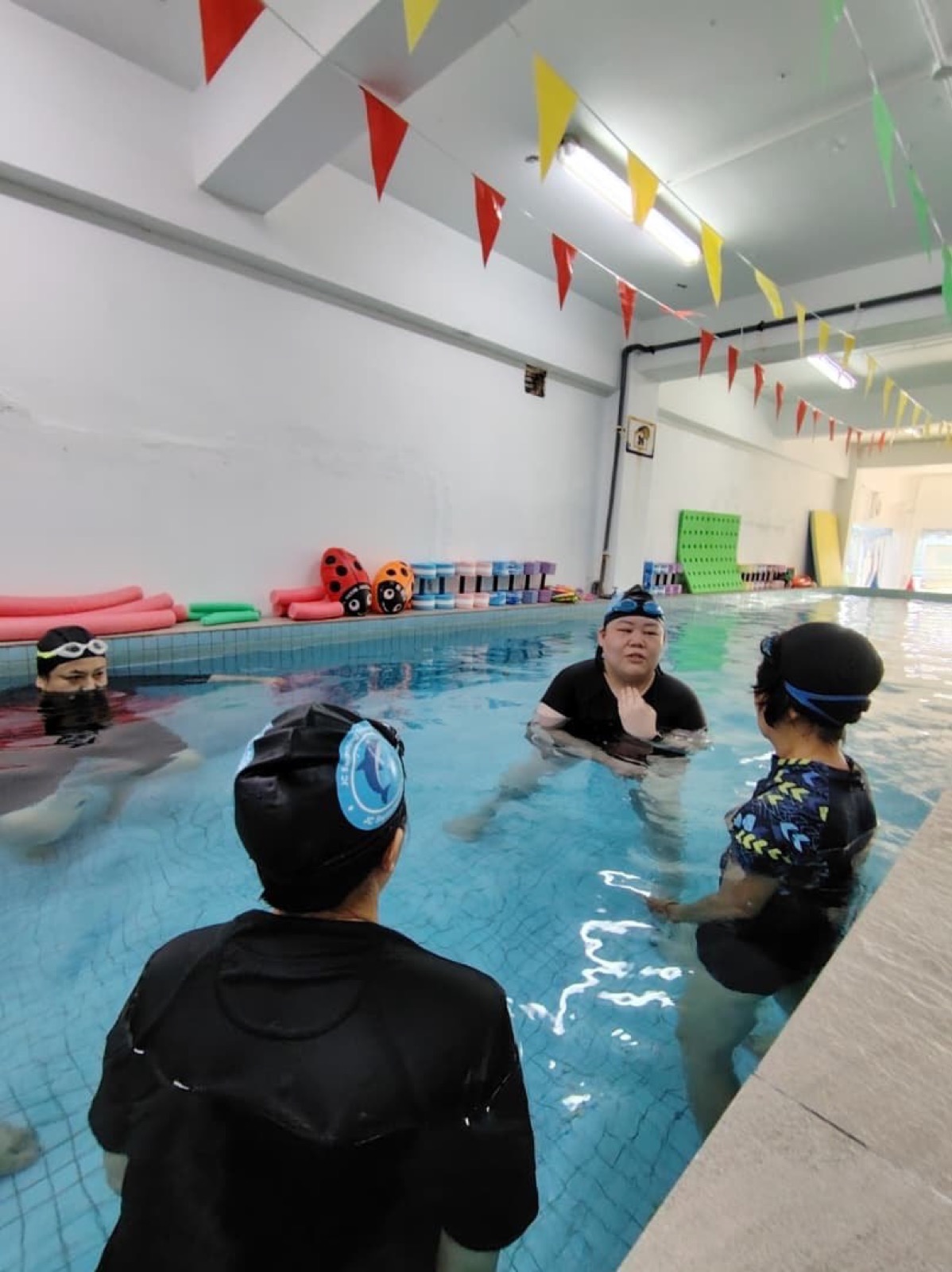 Trainee coaches practising poolside instruction under the guidance of an experienced JC coach
