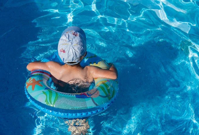 Toddler enjoying the water with a float